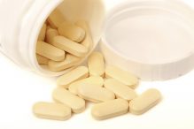 Medicine pills or capsules in bottle on white background.